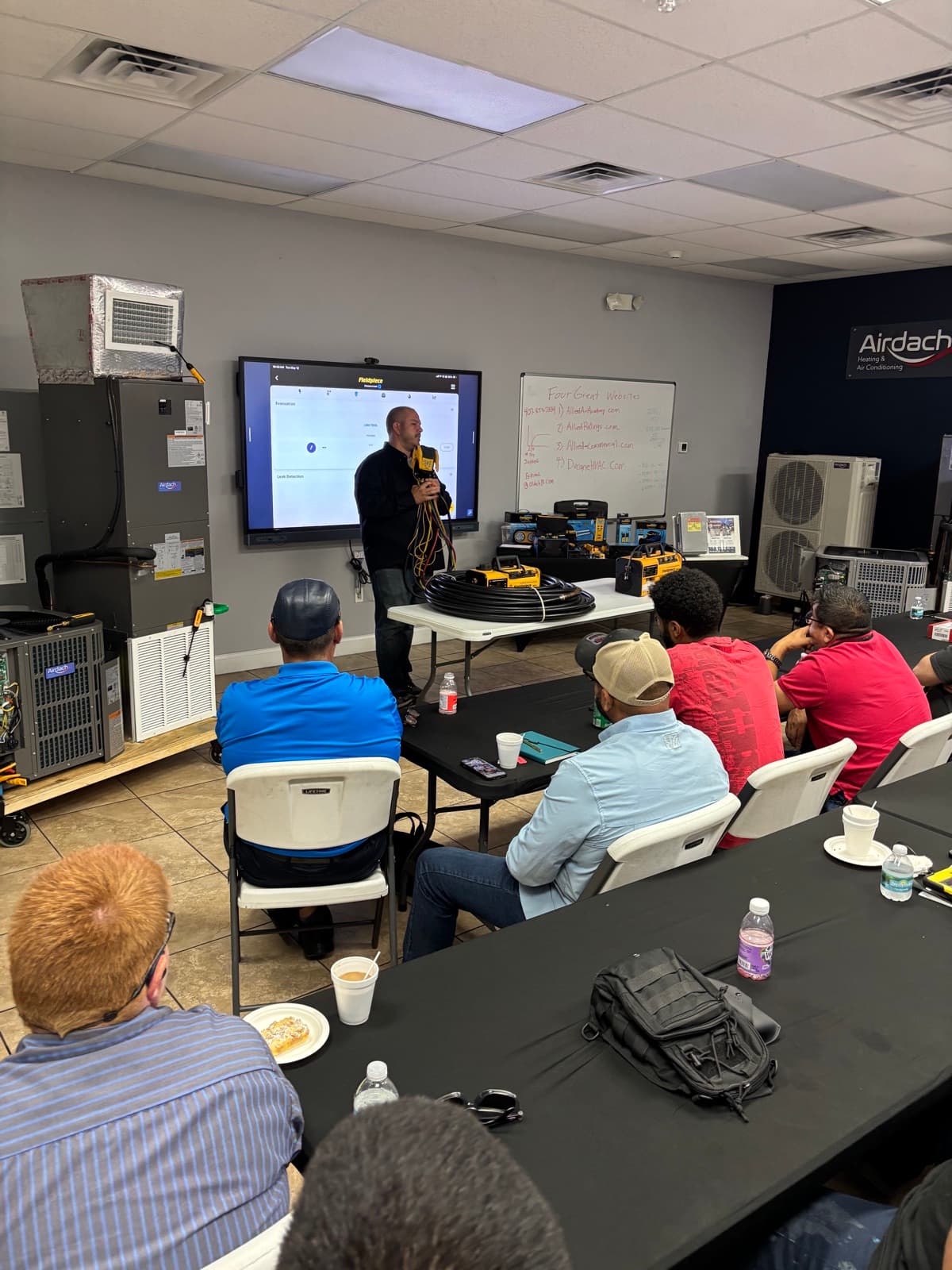 AMP rep demonstrating equipment to a room of technicians